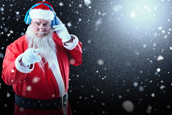 Santa claus écoute de la musique sur écouteurs — Photo