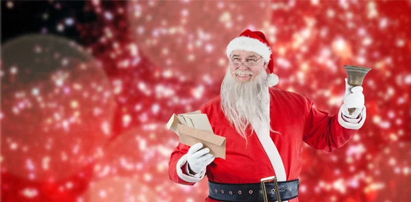 Санта-Клаус держит конверт и колокольчик — стоковое фото