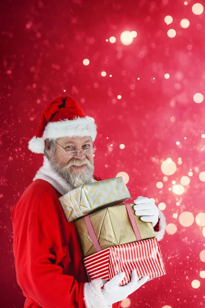 Jultomten håller julklappar — Stockfoto