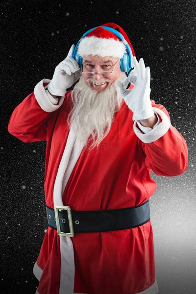 Jultomten som lyssnar på musik i hörlurar — Stockfoto