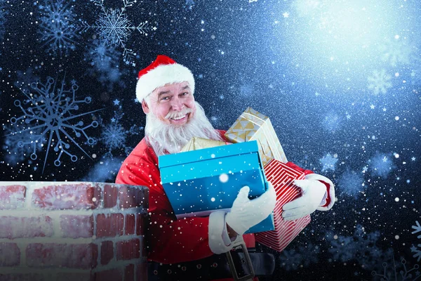 Санта-Клаус с различными подарками — стоковое фото