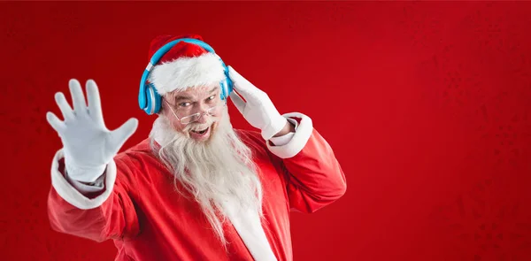 Jultomten som lyssnar på musik i hörlurar — Stockfoto