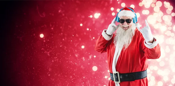 Санта-Клаус слушает музыку в наушниках — стоковое фото