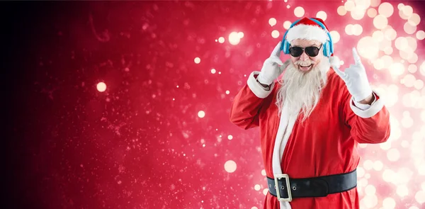 Papai Noel ouvindo música em fones de ouvido — Fotografia de Stock