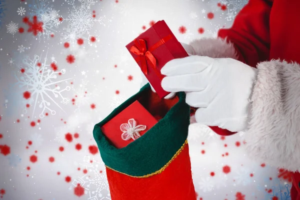 Santa claus putting presents in stockings — Stock Photo, Image