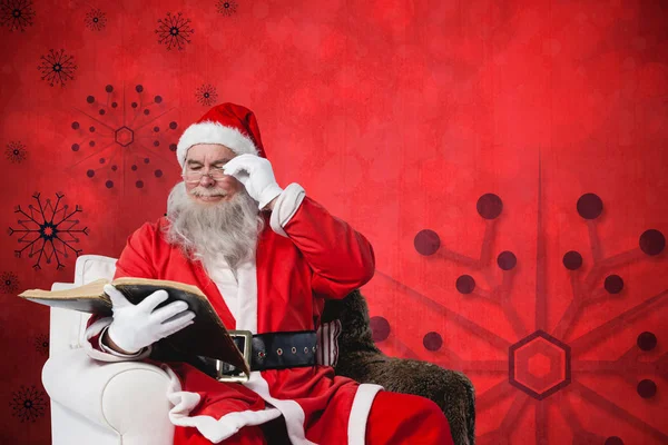 Weihnachtsmann liest Bibel auf Sessel — Stockfoto