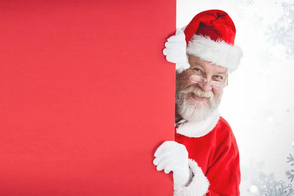 Santa claus gluren van rode bord — Stockfoto