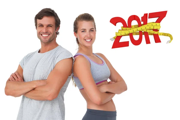 Sporty young couple with arms crossed — Stock Photo, Image