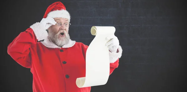 Santa claus reading scroll — Stock Photo, Image