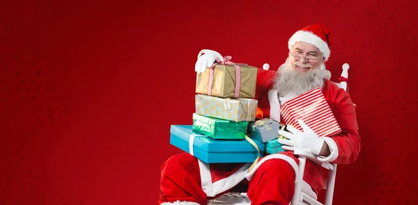 Santa claus drží vánoční dárky — Stock fotografie