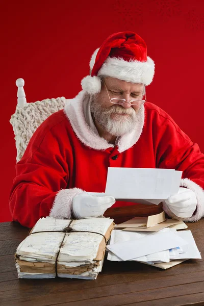 Santa claus reading wish lists — Stock Photo, Image