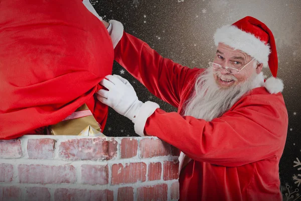 Санта Клаус с подарками на дымоходе — стоковое фото