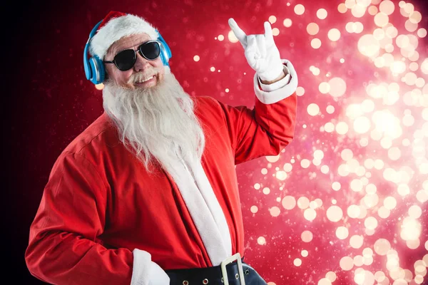 Santa claus listening to music on headphones — Stock Photo, Image