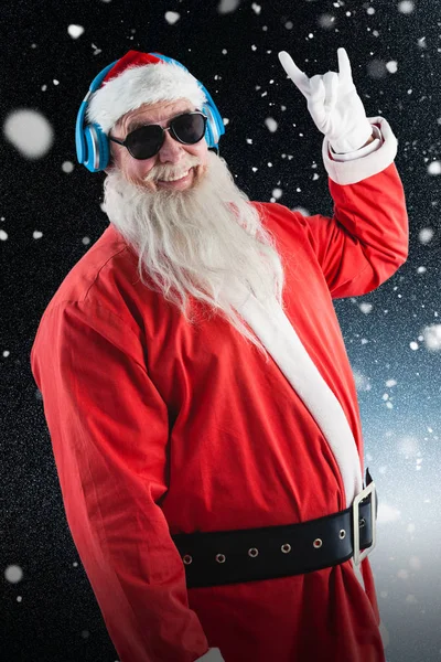 Santa claus listening to music on headphones — Stock Photo, Image