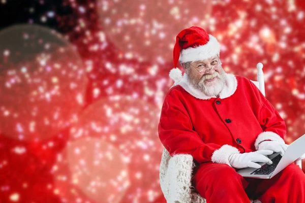 Alegre santa claus escribiendo en el ordenador portátil —  Fotos de Stock