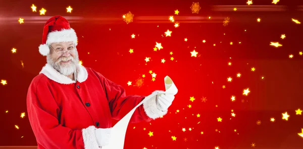 Santa claus s úsměvem a drží svitek — Stock fotografie