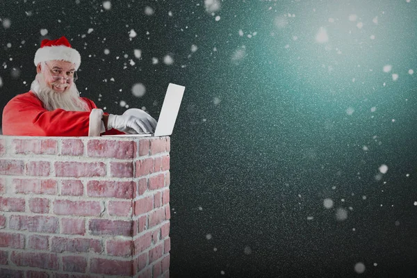 Santa claus using laptop on chimney — Stock Photo, Image