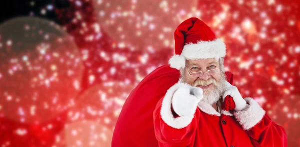 Santa claus carrying christmas bag Royalty Free Stock Images