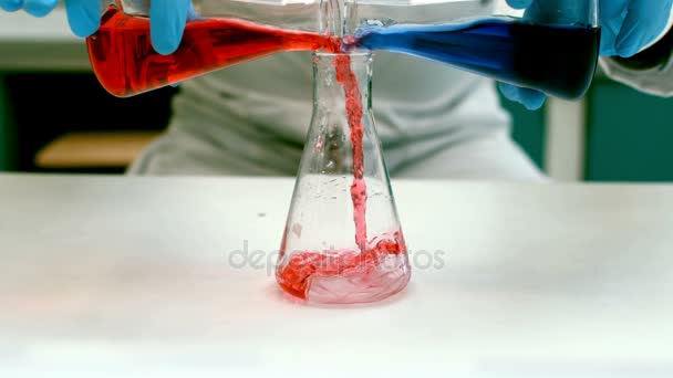 Científico vertiendo líquido en un frasco erlenmeyer — Vídeos de Stock