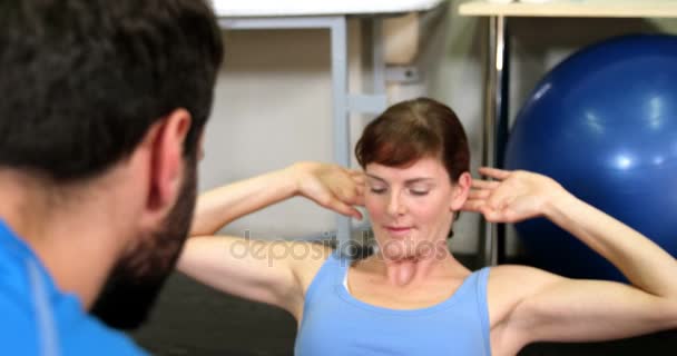 Male physiotherapist assisting a patient while exercising — Stock Video