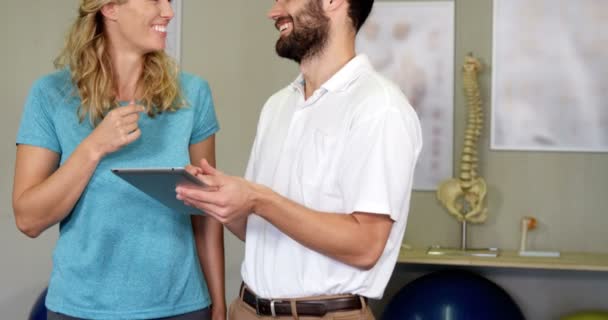 Fisioterapeuta mostrando tableta digital a mujer — Vídeos de Stock