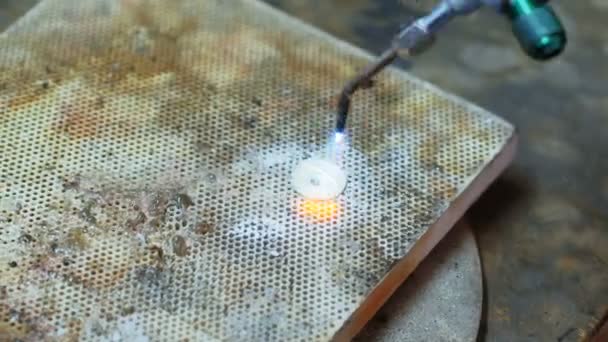 Ремесленница задувает факел, чтобы расплавить металл — стоковое видео