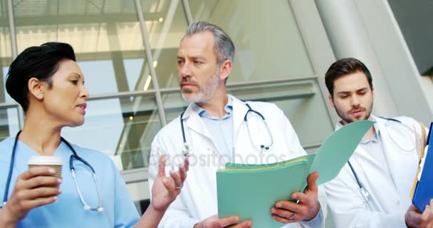 Doctores discutiendo mientras caminan en el hospital — Vídeos de Stock