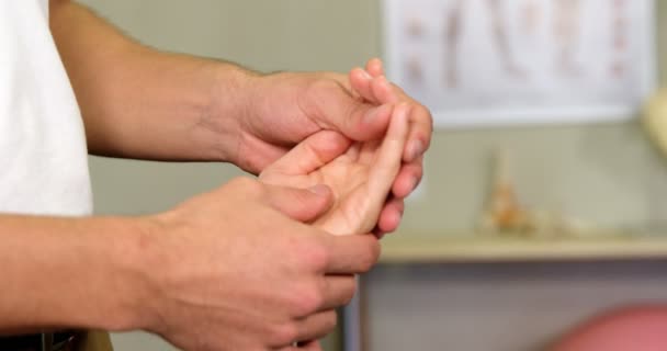 Fisioterapeuta masculino dando masaje de manos a paciente femenino — Vídeos de Stock