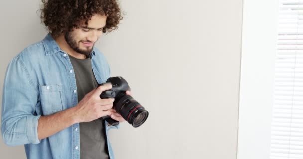 Fotógrafo mirando fotos en cámara — Vídeo de stock