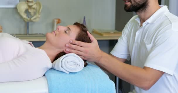 Physiotherapeutin gibt einer Frau eine Kopfmassage — Stockvideo