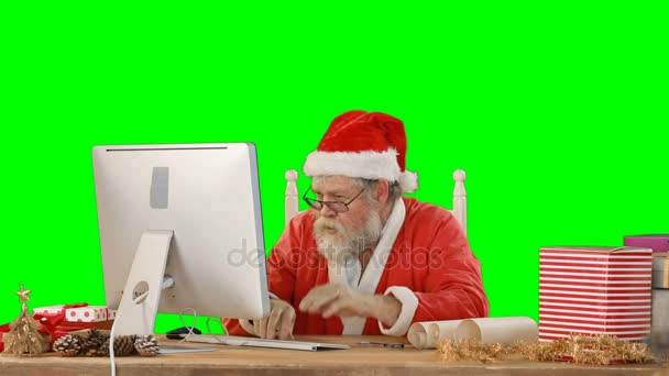 Санта-Клаус разговаривает за компьютером — стоковое видео