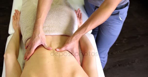 Физиотерапевт, делающий массаж спины женщине — стоковое видео