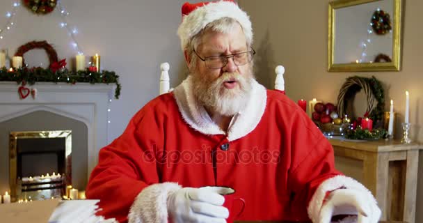 Санта-Клаус расслабляется, пьет кофе — стоковое видео