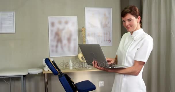 Fisioterapeuta femenina usando laptop — Vídeos de Stock