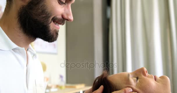 Фізіотерапевт дає масаж голови пацієнту — стокове відео