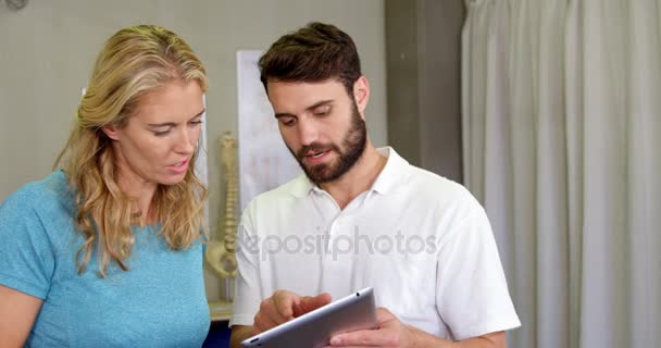 物理治疗师显示数字平板电脑到女人 — 图库视频影像