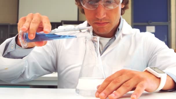 Scientist pouring test tube liquid into a erlenmeyer flask — Stock Video