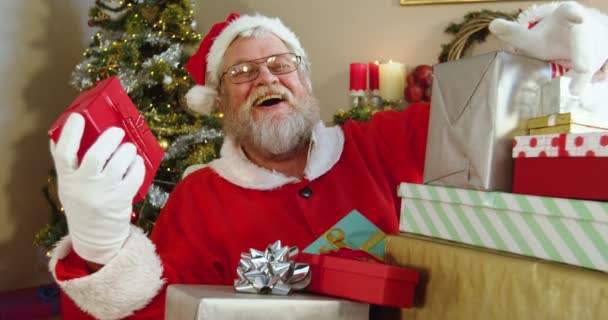 Santa Claus sosteniendo varias cajas de regalo — Vídeos de Stock