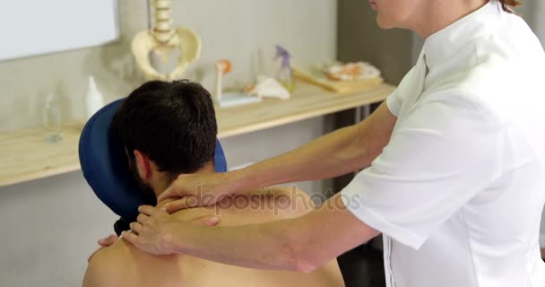 Fisioterapeuta dando masaje de espalda a un paciente — Vídeos de Stock