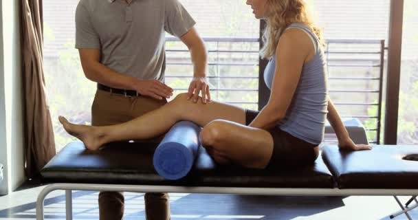Мужской физиотерапевт делает массаж ног пациентке — стоковое видео