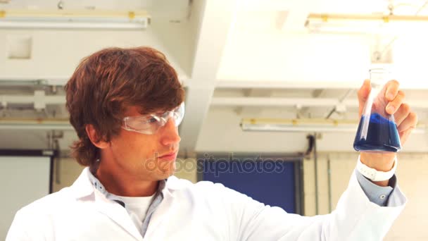 Scientist holding erlenmeyer flask with liquid — Stock Video