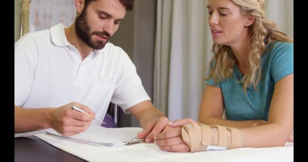 Mannelijke fysiotherapeut behandeling van een patiënt — Stockvideo