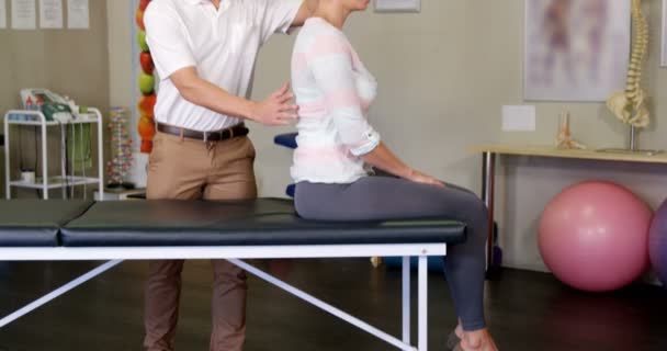 Fisioterapeuta masculino dando masaje de espalda a paciente femenino — Vídeos de Stock