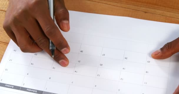 Männliche Markierung mit Stift auf Kalender — Stockvideo
