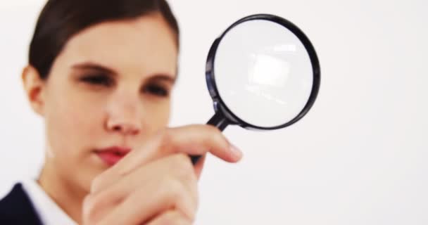 Kobieta patrząc przez szkło powiększające — Wideo stockowe