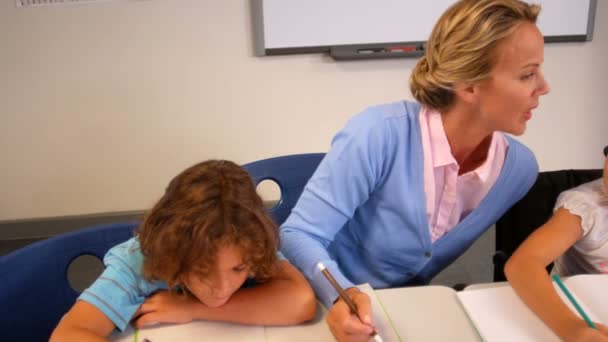 Insegnante aiutare i bambini con i loro compiti — Video Stock