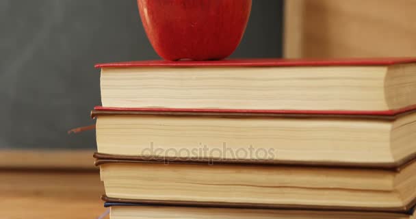 Apilamiento de libros con manzana roja — Vídeos de Stock