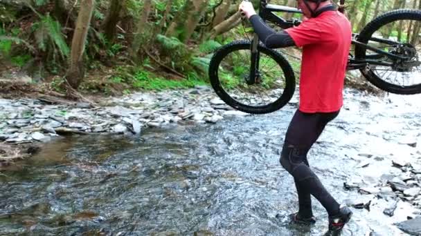 Mountainbiker trägt Fahrrad — Stockvideo