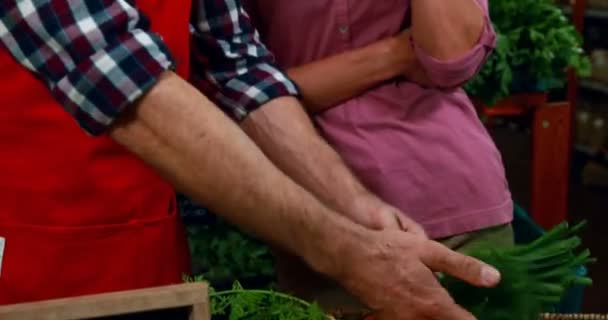 Bir kadın alışveriş yeşil soğan yardımcı erkek personel — Stok video