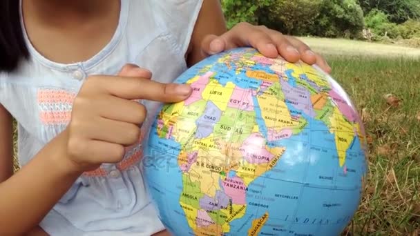 Sorrindo menina olhando para o globo — Vídeo de Stock